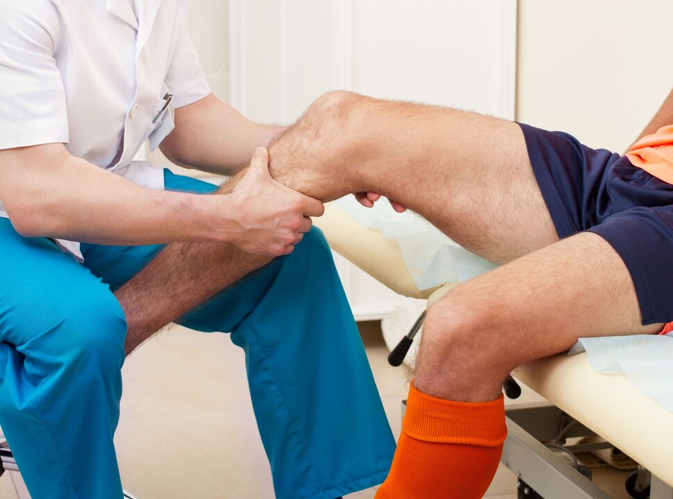 examination of the aching joint by a doctor